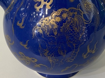 Een paar Chinese poederblauwe dekselkannen met verguld decor van kylins, Kangxi
