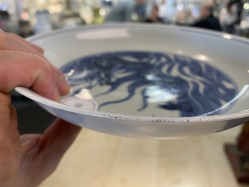 Une assiette en porcelaine de Chine en bleu et blanc &agrave; d&eacute;cor d'un dragon et d'un carpe, marque de Kangxi, R&eacute;publique