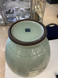 Een paar Chinese monochrome celadon vazen met onderglazuur decor op houten sokkels, Qianlong merk, 18/19e eeuw