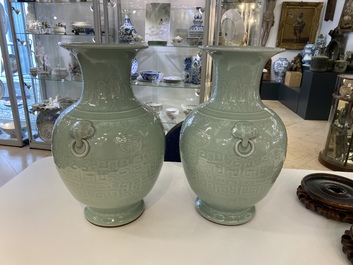 A pair of Chinese monochrome celadon vases with underglaze design on wooden stands, Qianlong mark, 18/19th C.