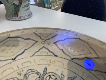 Un plat en gr&egrave;s porcelaineux d'Annam ou Vietnam &agrave; d&eacute;cor d'un lion bouddhiste en bleu, blanc, vert et dor&eacute;, 14/15&egrave;me