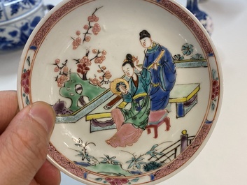 Een Chinese famille rose kop en schotel met een koppel op een terras, Qianlong