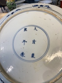 Un plat en porcelaine de Chine en bleu et blanc &agrave; d&eacute;cor de deux femmes et deux lapins dans un jardin, marque et &eacute;poque de Kangxi