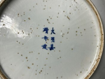 Een Chinese monochrome witte schotel met gekerfd decor van twee feniksen, Jiajing merk, Ming