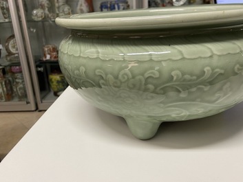 Een Chinese driepotige monochrome celadon wierookbrander met pioenslingers, 18/19e eeuw