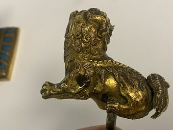 A pair of Chinese gilt bronze Buddhist lions on champlev&eacute; enamel bases, 18/19th C.