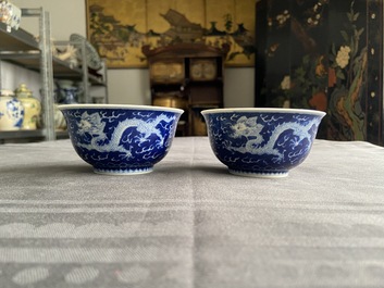Une paire de bols en porcelaine de Chine en bleu et blanc &agrave; d&eacute;cor de dragons, marque de Kangxi, 19/20&egrave;me