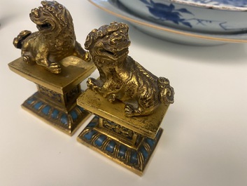 A pair of Chinese gilt bronze Buddhist lions on champlev&eacute; enamel bases, 18/19th C.