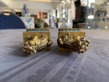 A pair of Chinese gilt bronze Buddhist lions on champlev&eacute; enamel bases, 18/19th C.