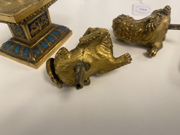 A pair of Chinese gilt bronze Buddhist lions on champlev&eacute; enamel bases, 18/19th C.