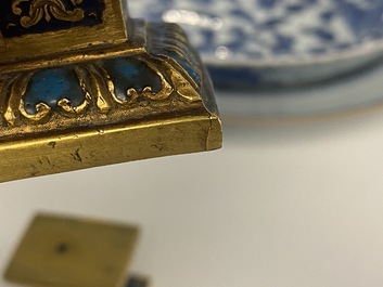 A pair of Chinese gilt bronze Buddhist lions on champlev&eacute; enamel bases, 18/19th C.