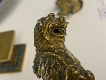 A pair of Chinese gilt bronze Buddhist lions on champlev&eacute; enamel bases, 18/19th C.