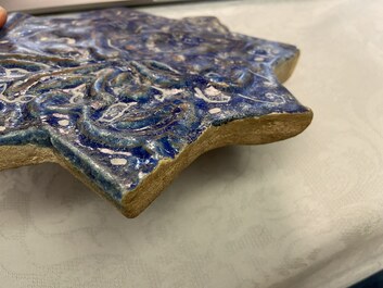 A molded Ilkhanid Lajvardina blue-ground star-shaped tile, Iran, 13/14th C.