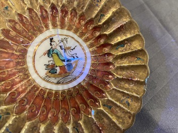 A lobed Chinese gilded famille rose 'lotus' cup and saucer and one depicting roosters, Yongzheng/Qianlong