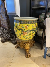 A Chinese yellow-ground famille verte 'dragons' fish bowl on gilded wooden stand, 19th C.