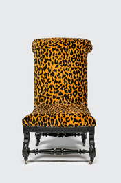 An ebonised wooden 'leopard design' chair on wheels, 19/20th C.