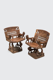 An African wooden salon set comprising two chairs and a coffee table, 20th C.