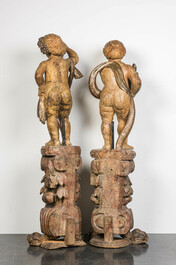 A pair of large polychrome wooden allegorical putti on bases, probably Italy, 18th C.