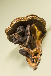 A partly gilt and patinated wooden wall bracket with an atlant, probably Italy, 18/19th C.