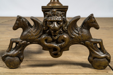 A pair of bronze andirons with lion heads and winged horses, 19/20th C.