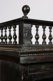 A Spanish ebonised wooden display cabinet on richly carved armorial stand, 19th C.