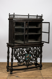 A Spanish ebonised wooden display cabinet on richly carved armorial stand, 19th C.