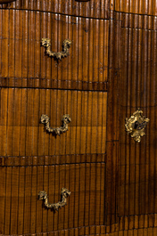 A German low ribbed wooden cabinet of drawers with a central door, 19th C.