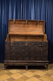 A large French wooden 'bahut' trunk with leather upholstery and wrought iron fittings on a wooden base, dated 1599 but possibly later