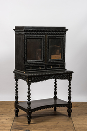 An ebonised wooden cabinet on stand with mirrored doors, 19th C.