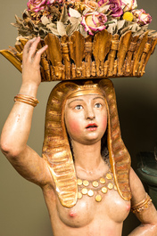 A polychrome terracotta 'Egyptomania' sculpture of an Egyptian lady with a flower basket, illegibly signed, dated 1881