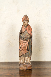 A Flemish carved and polychromed oak figure of a bishop on an armorial base, ca. 1500