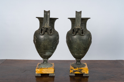 A pair of neoclassical style vases with charioteers on a Siena marble base, 19/20th C.