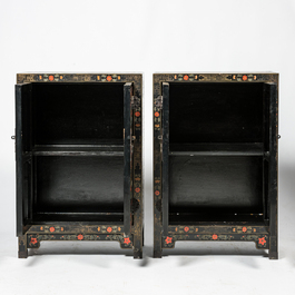 A pair of Chinese black lacquered wooden two-door cabinets with floral design, 20th C.