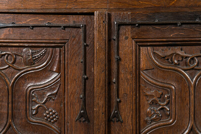 A rare large Flemish oak four-door cupboard with carved X-panels and wrought iron mounts, 1st half 16th C.