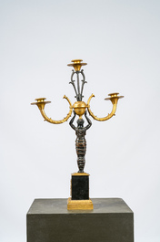 Een Franse vergulde en gepatineerde bronzen kandelaar met drie lichtpunten, 19e eeuw