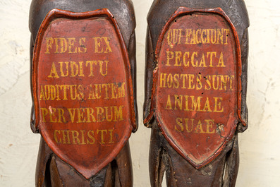 A pair of polychromed wooden reliefs depicting atlants bearing inscribed shields, 17th C.