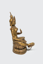 A large gilt copper figure of Tara seated on a lotus throne, India or Nepal, 20th C.