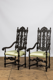 A pair of ebonised wooden armchairs with green silk upholstery, 19th C.