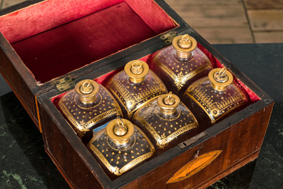 An English mahogany liqueur cellar with six partly gilt carafes, 19th C.