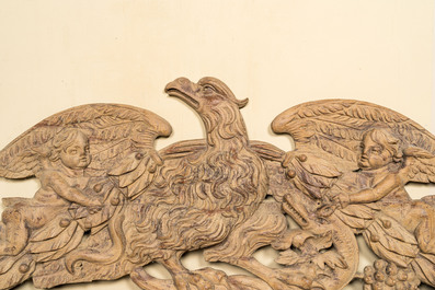 A large leached oak relief depicting an eagle slaying a serpent and two angels, 18th C.