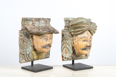 A pair of polychromed wooden heads on metal stands, India, 19/20th C.