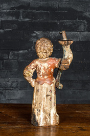 A wrought iron candlestick-mounted polychromed wooden figure of a lady holding a torch, 17th C.