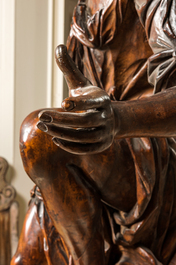 A large walnut figure of an angel, Flanders, 17th C., on a later stand