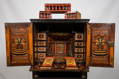 A neoclassical ebonised wooden cabinet on foot with an interior with parquetry and polychrome design, 18th C. and later