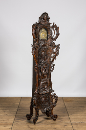 A richly carved walnut tripod clock, 19th C.