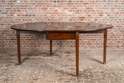 An oval English mahogany drop leaf table, 19th C.