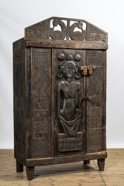 A decorative wooden African-inspired single-door cupboard, 20th C.