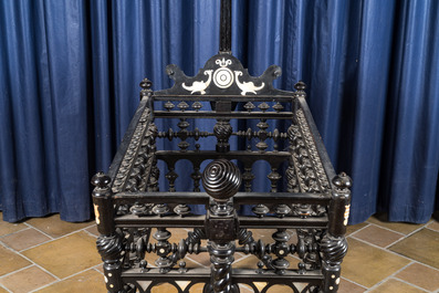 An attractive ebony-inlaid ebonised wooden cradle, 19th C.