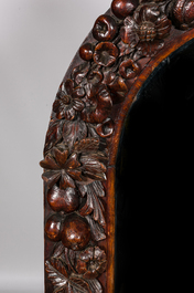 A richly sculpted oak wooden mirror, 19th C.