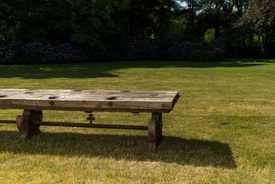 Een indrukwekkende lange houten tafel met uitsparingen uit de eetzaal van een weeshuis of klooster, 19e eeuw